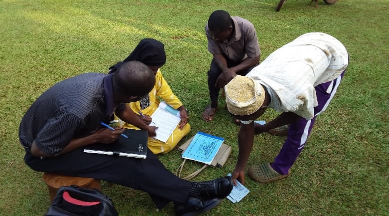 Group members completing savings records and passbooks